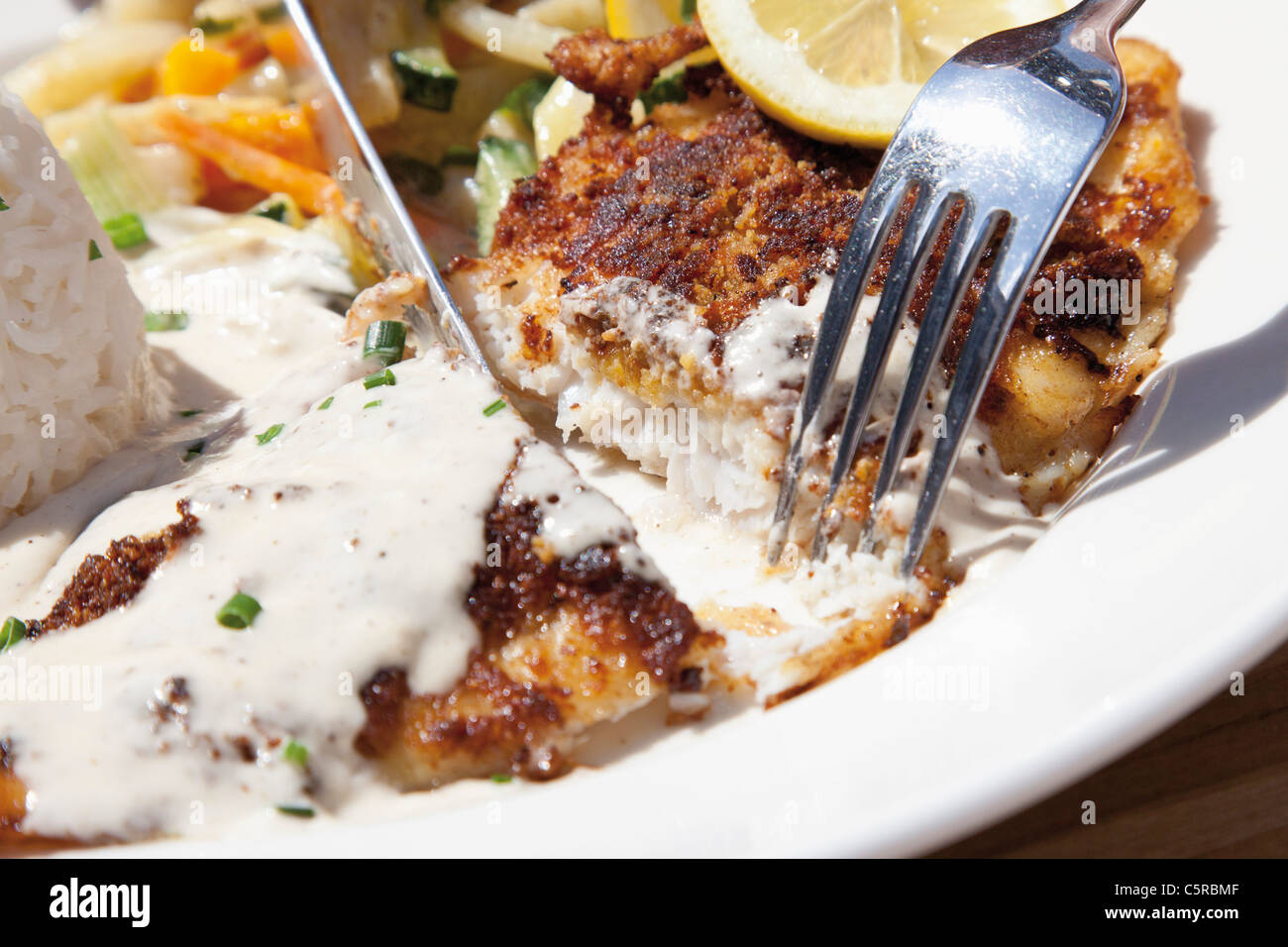 Nahaufnahme von gebratenen Tiefsee Barsch mit Duftreis und Rahmsauce Stockfoto