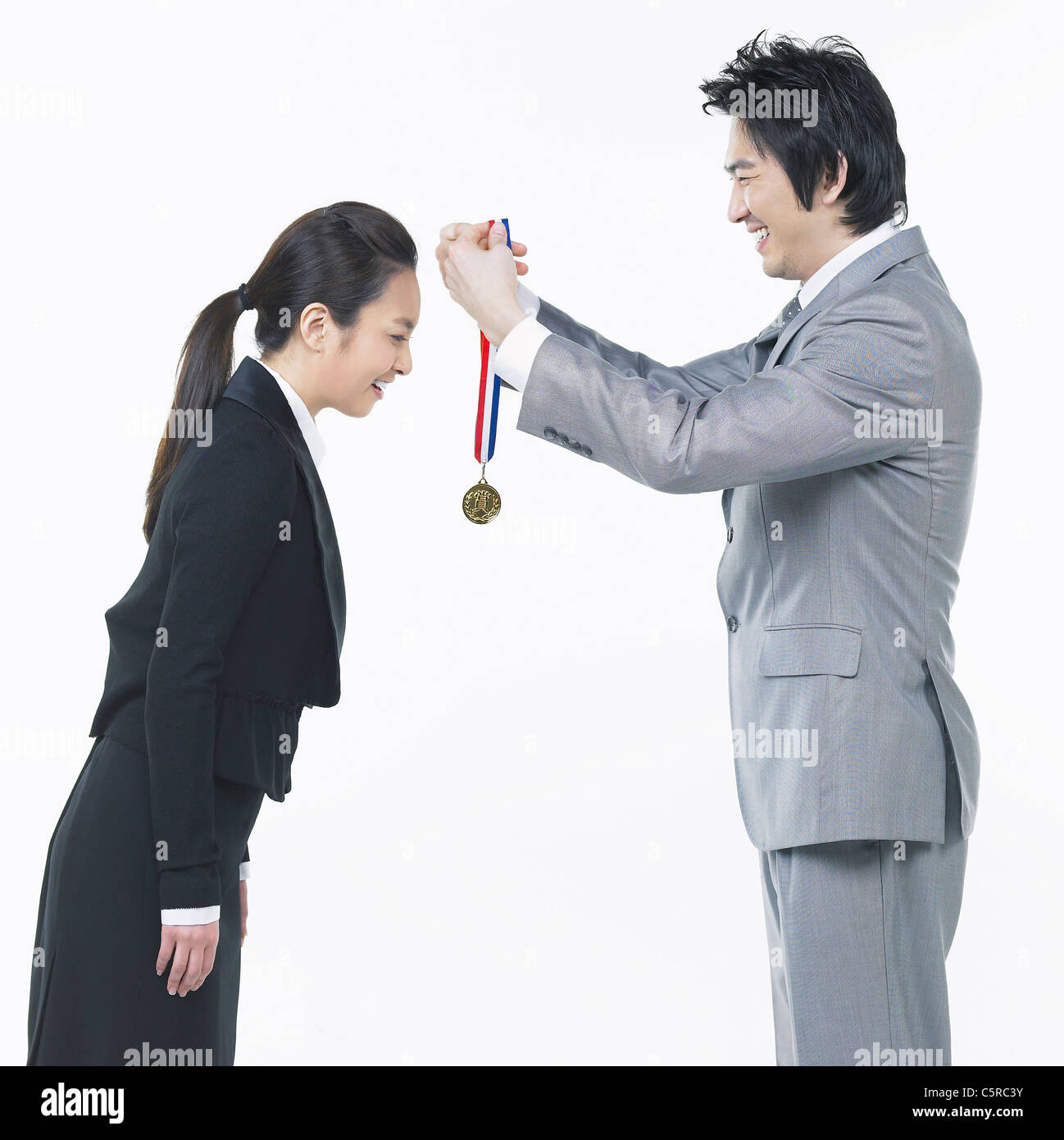 Ein Mann, der Verleihung einer Medaille an einer Frau Stockfoto