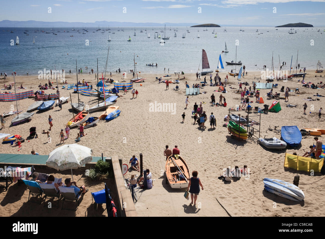 Urlauber Sonnenbaden am beliebten Strand mit Blick auf die Cardigan Bay im Sommer Sonnenschein. Abersoch Lleyn Halbinsel North Wales UK. Stockfoto