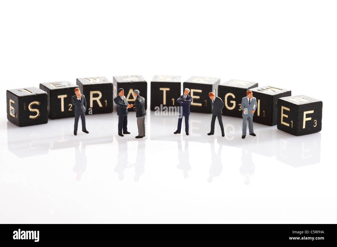 Scrabble Fliesen bilden die Wort Strategie im Vordergrund Business Männer Figuren Stockfoto