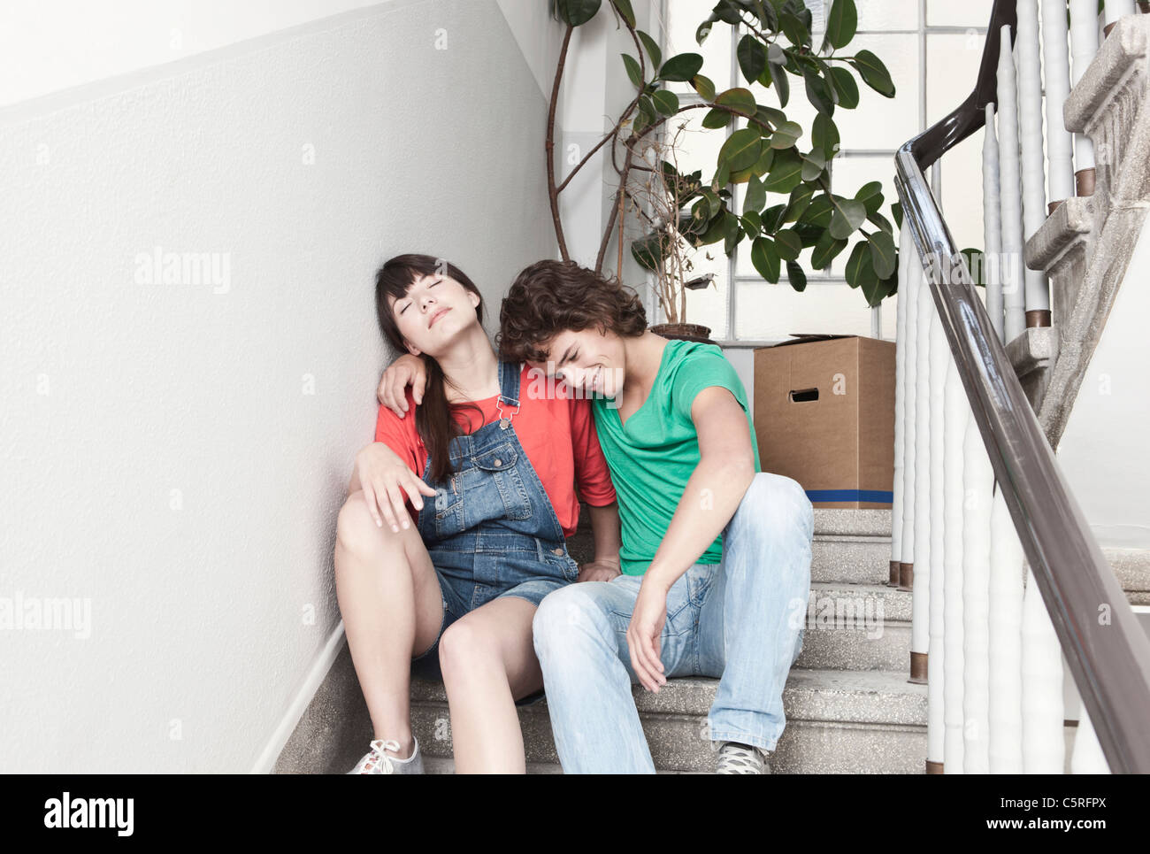 Deutschland, Köln, junges Paar ruht auf der Treppe in die Renovierung der Wohnung Stockfoto