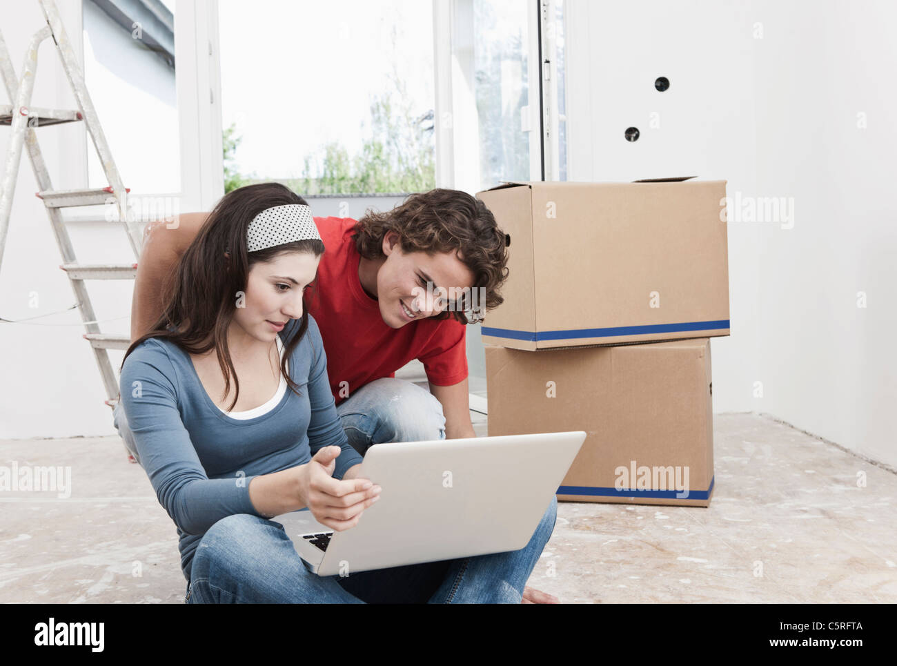 Deutschland, Köln, junges Paar mit Laptop in die Renovierung der Wohnung Stockfoto