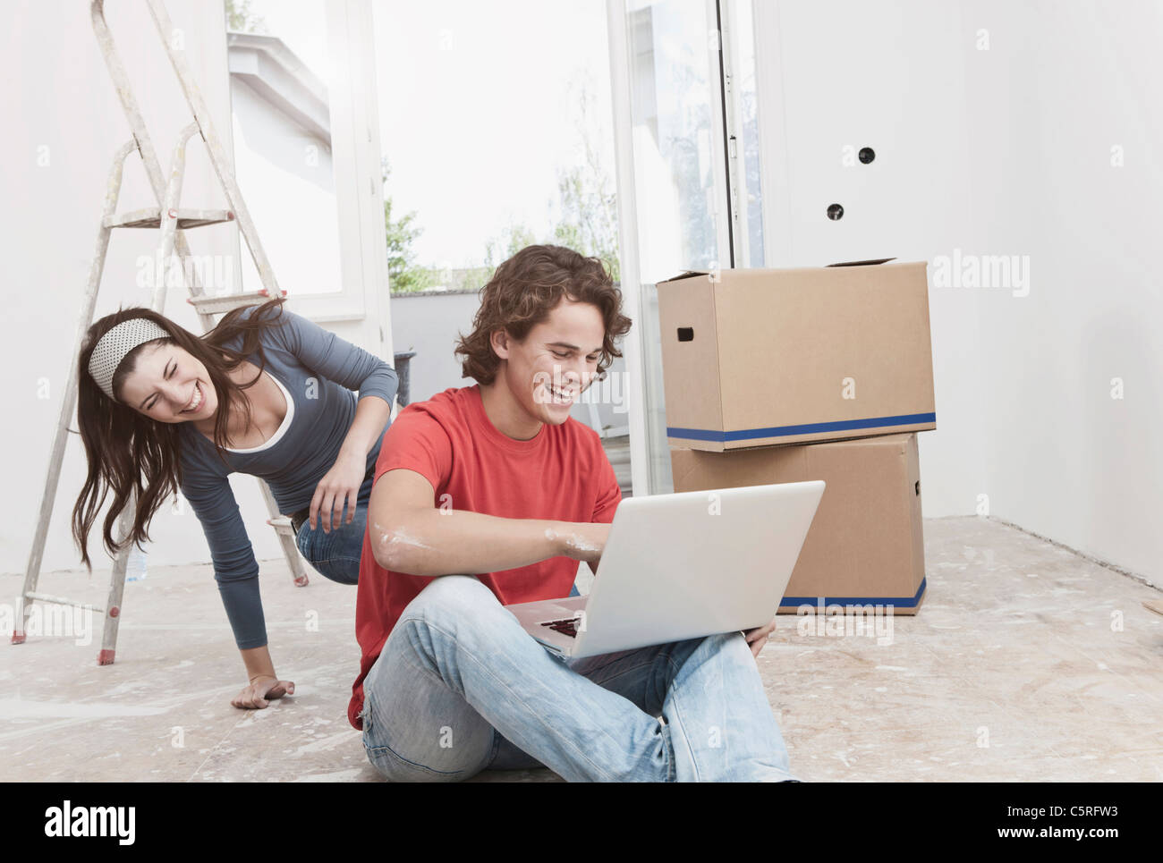 Deutschland, Köln, junges Paar mit Laptop in die Renovierung der Wohnung Stockfoto