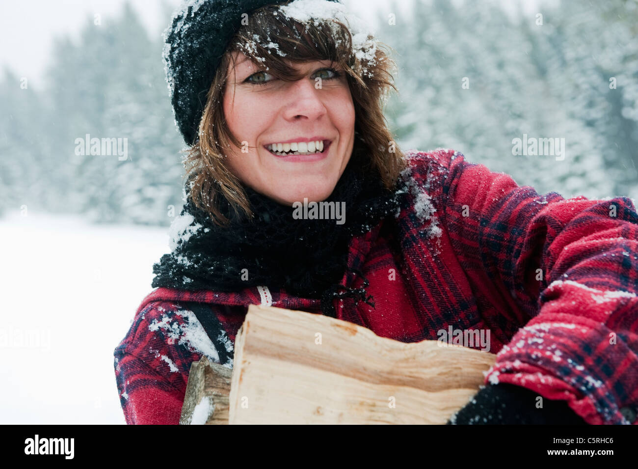 Österreich, Salzburger Land, Flachau, junge Frau mit Brennholz Stockfoto