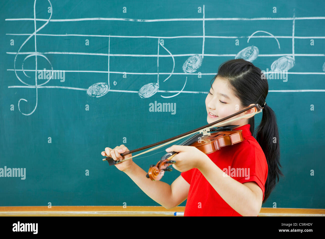 Eine asiatische Mädchen spielen eine Geige Stockfoto