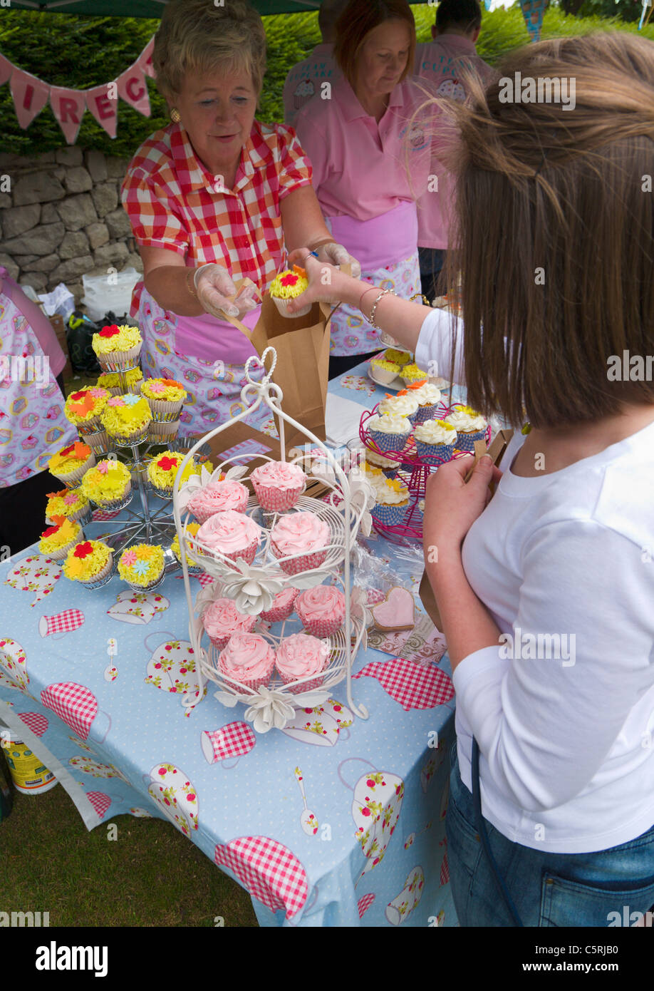 Mädchen, Kauf einer Tasse Kuchens, England Stockfoto