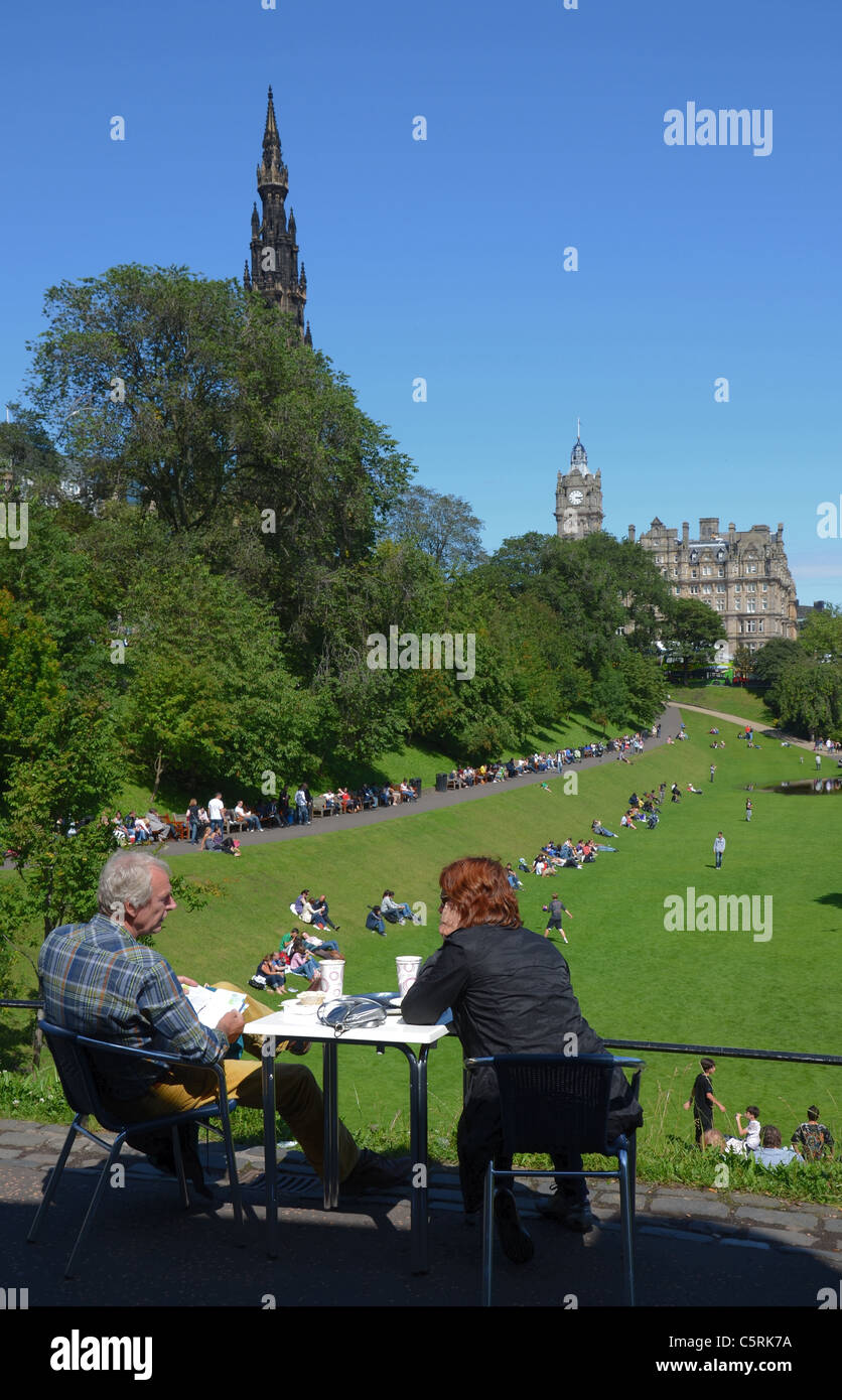 Ein paar genießen Sie einen Kaffee und genießen Sie den Blick über Princes Street Gardens in Richtung Scott Monument und das Balmoral Hotel. Stockfoto