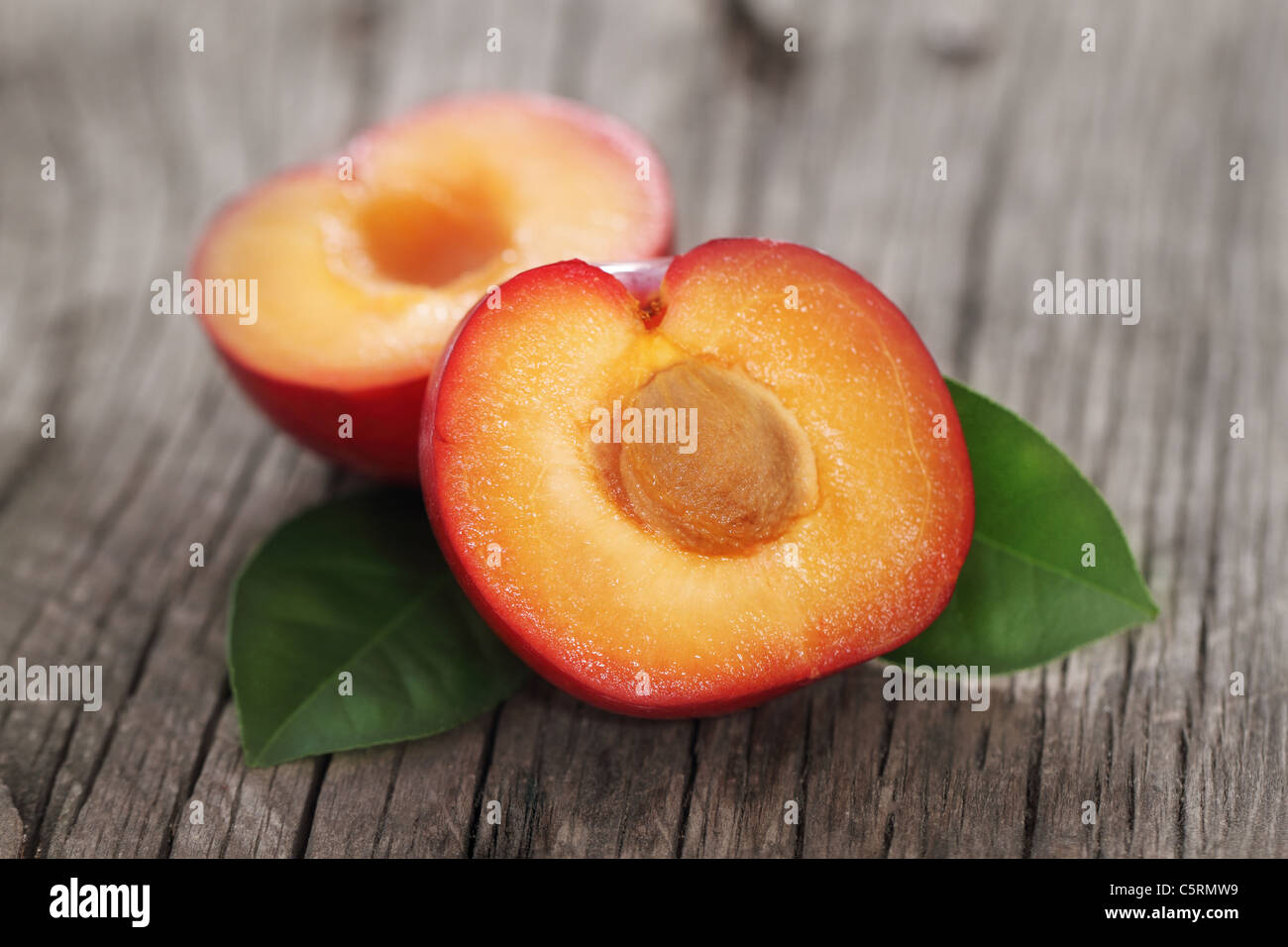 Einzelne frische rote Pflaume auf hölzernen Hintergrund Stockfoto