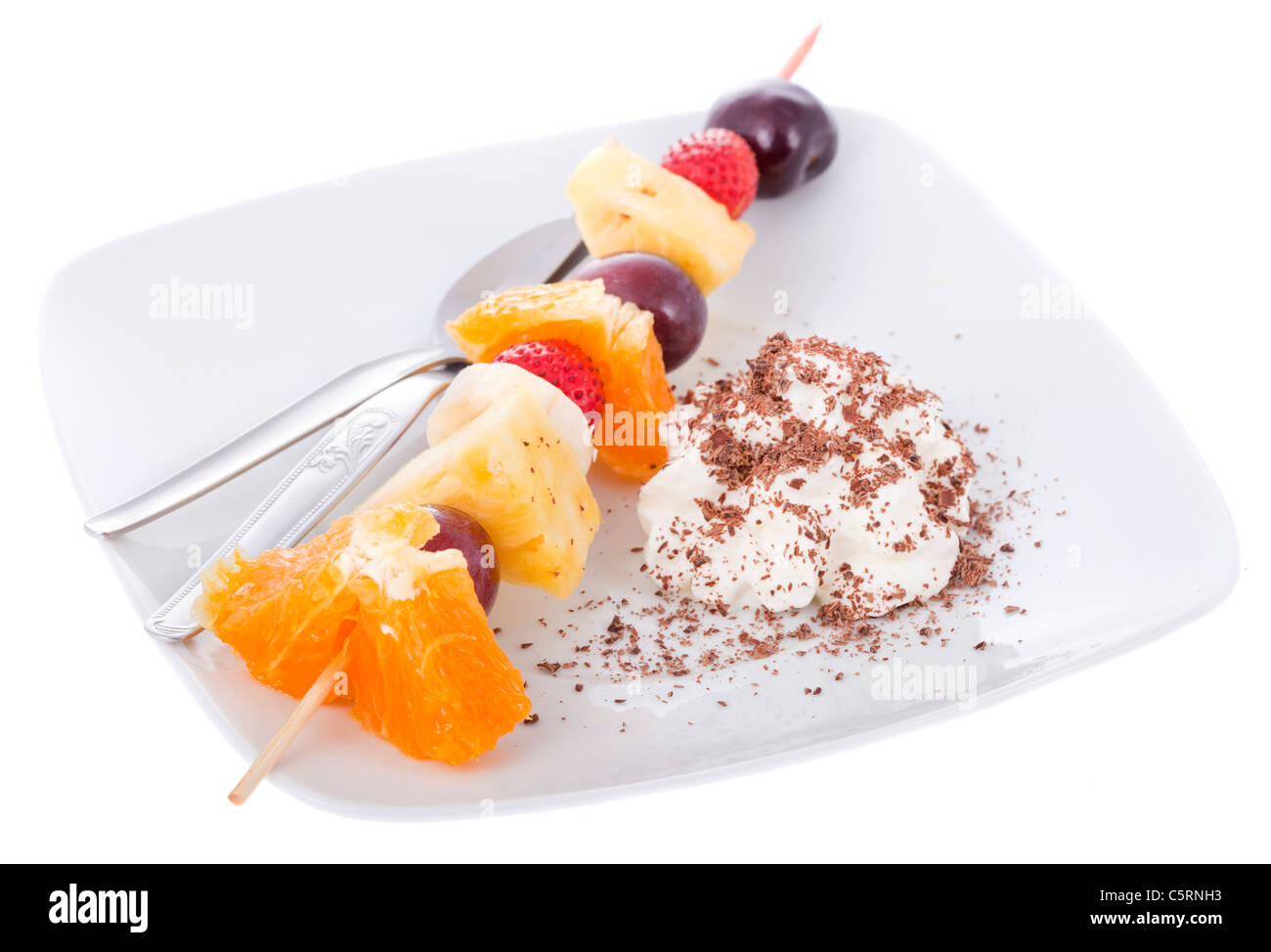 Ein Spieß von frischen Früchten mit Chantilly und streifte Schokolade. Stockfoto