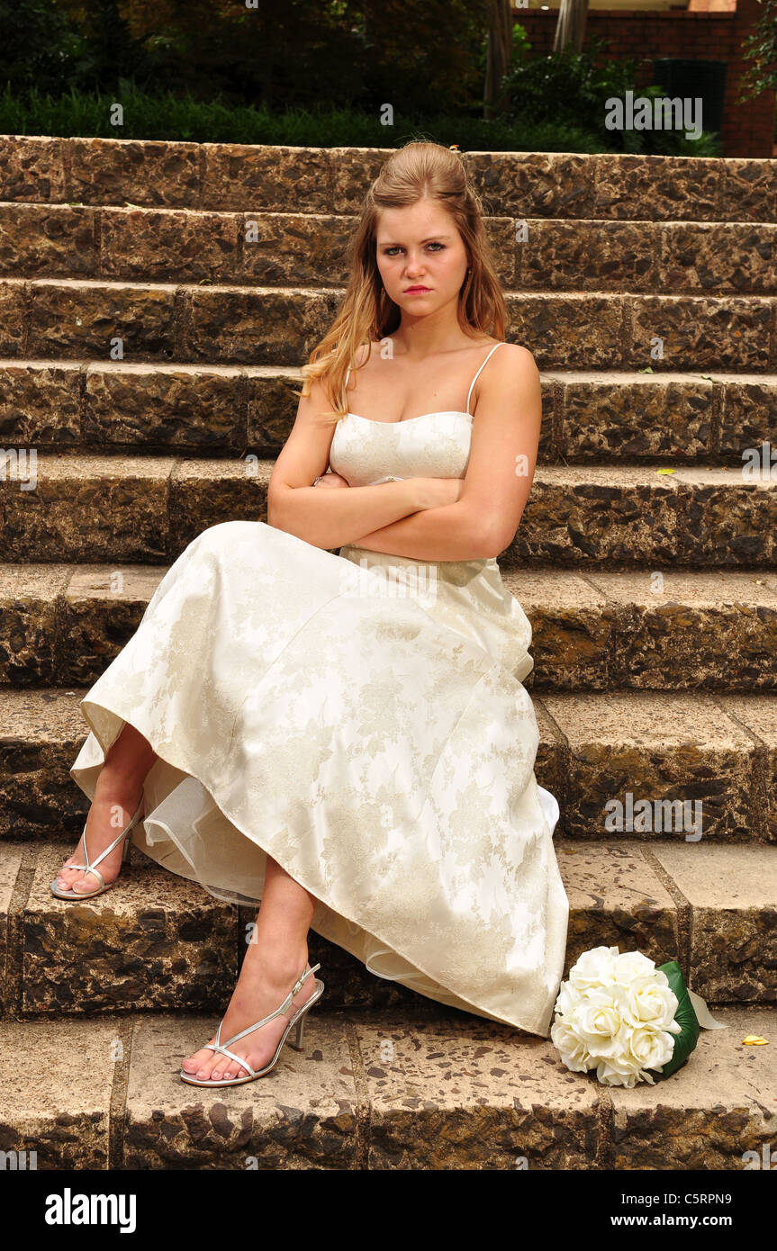 Ein 20 stand etwas blond kaukasischen Braut auf steinernen Stufen in der Kirche nachdem er sitzt bei ihrer Hochzeit. Stockfoto