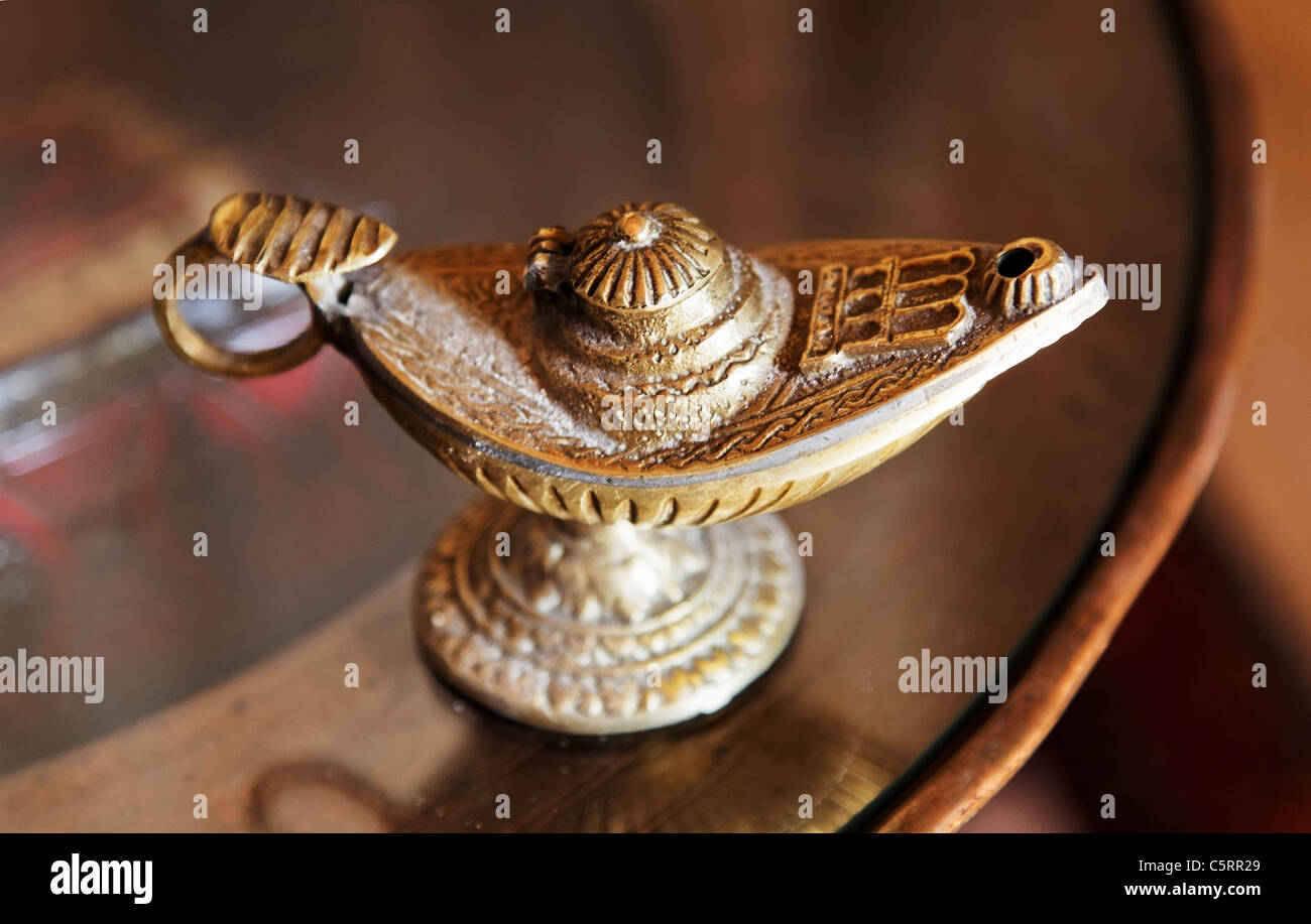 reich verzierte Messinglampe mit Griff auf eine Runde Beistelltisch. Landschaft, Raum und Kopie Anbaufläche. Stockfoto