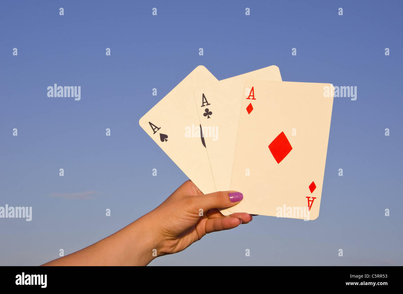 Hand hält gute Karten beim Poker. Drei einer Art. Asse. Stockfoto