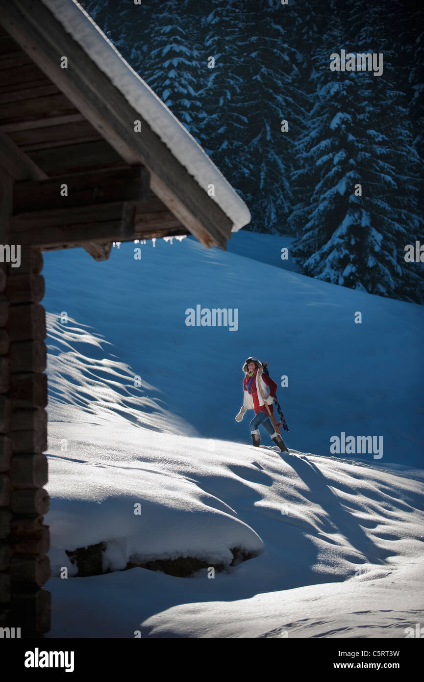 Österreich, Salzburger Land, Flachau, junge Frau, die zu Fuß mit Schlitten im Schnee Stockfoto