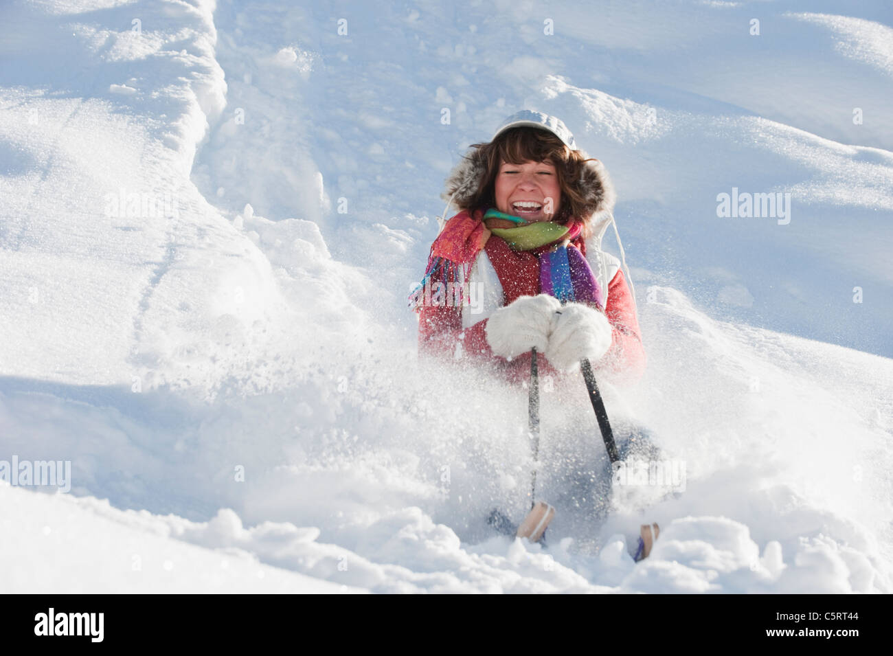 Österreich, Salzburger Land, Flachau, junge Frau reitet auf Schlitten im Schnee Stockfoto