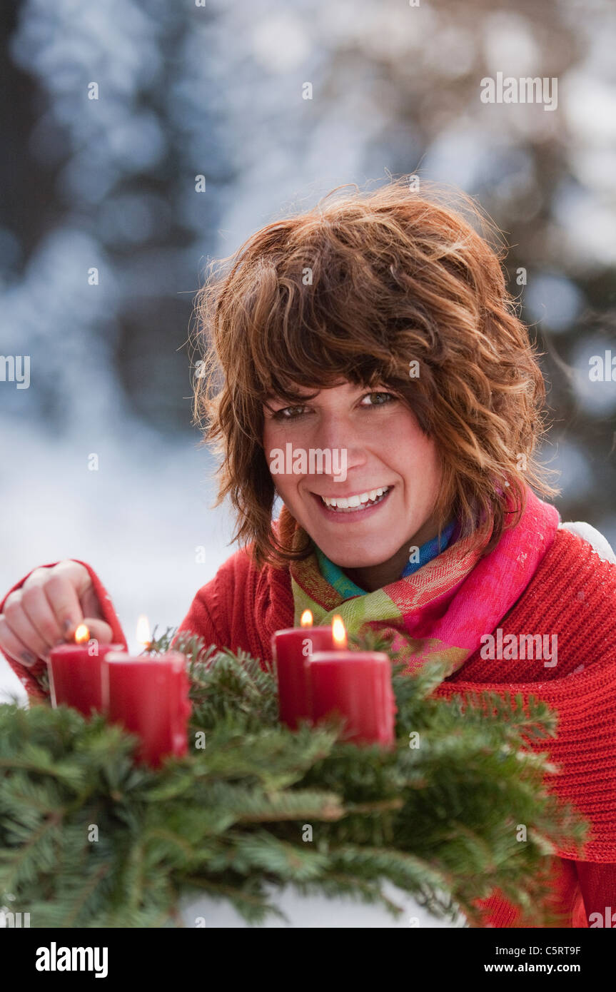 Österreich, Salzburger Land, Flachau, Nahaufnahme von junge Frau zünden Kerzen Adventskranz im Winter Stockfoto