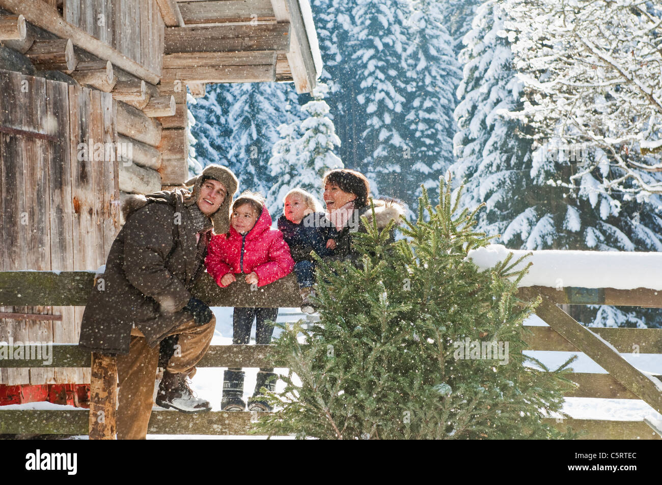 Österreich, Salzburger Land, Flachau, Familie stützte sich auf Zaun im Schnee Stockfoto