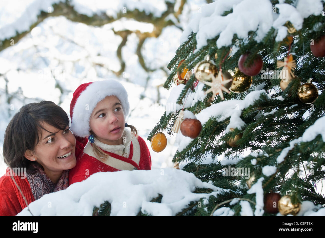 Österreich, Salzburger Land, Flachau, junge Mutter und Tochter betrachten Weihnachtsbaum Stockfoto