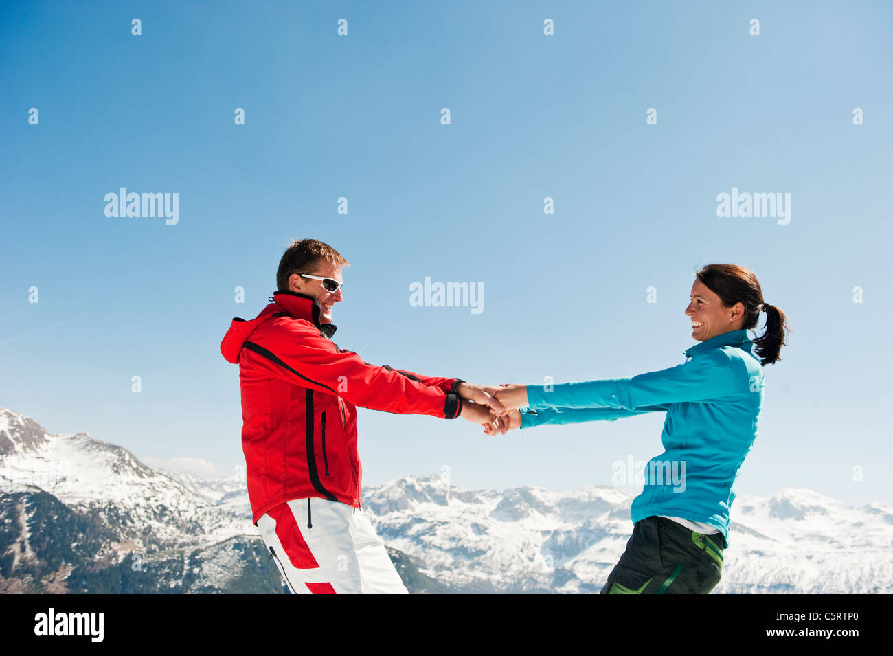 Österreich, Salzburger Land, Altenmarkt-Zauchensee, Mitte erwachsenes paar Hand in Hand und drehen im winter Stockfoto