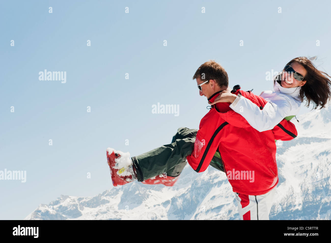 Österreich, Salzburger Land, Altenmarkt-Zauchensee, Mitte erwachsenen Mann trägt Frau im winter Stockfoto