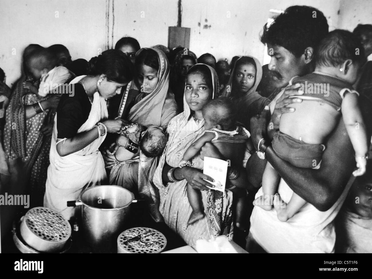 Eltern mit ihren Babys und Kindern auf warten Immunisierung Jabs und Impfungen gegen Polio Diphtherie Orissa Provinz Indien Asien Stockfoto