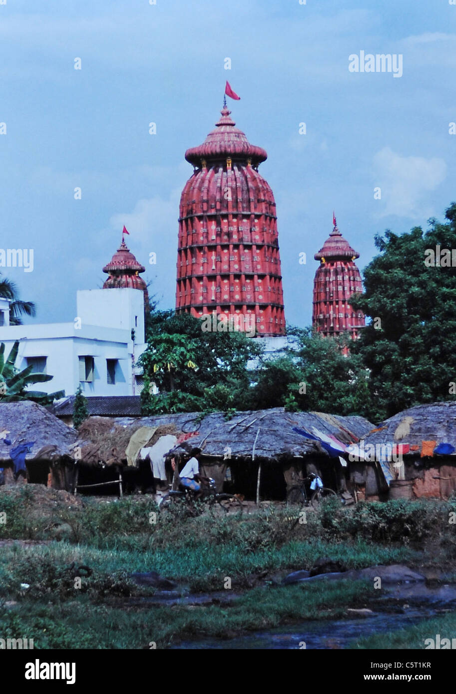 Religiöse Tempel erhebt sich über schlechte Wohnungen der Menschen in der Stadt Bhubaneswar im Großraum Orissa in Indien 1992 Stockfoto