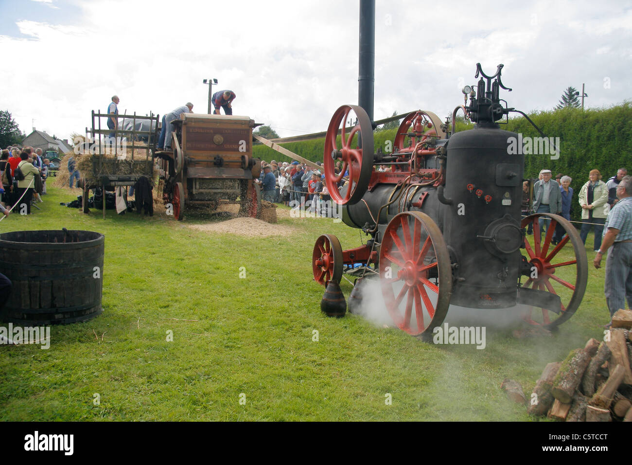 Tag alten Handwerks landwirtschaftliche Dreschmaschine, angetrieben von der Dampftraktor (St Fraimbault, Orne, Frankreich). Stockfoto