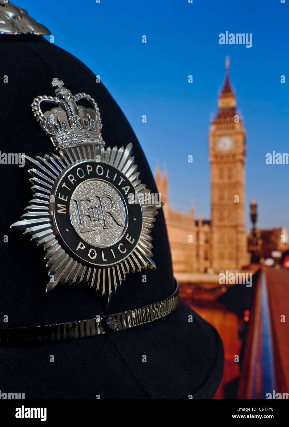 Polizeihelm und Dienstmarke mit Houses of Parliament und der Themse dahinter. Konzept Police Law Politics Westminster London UK Stockfoto