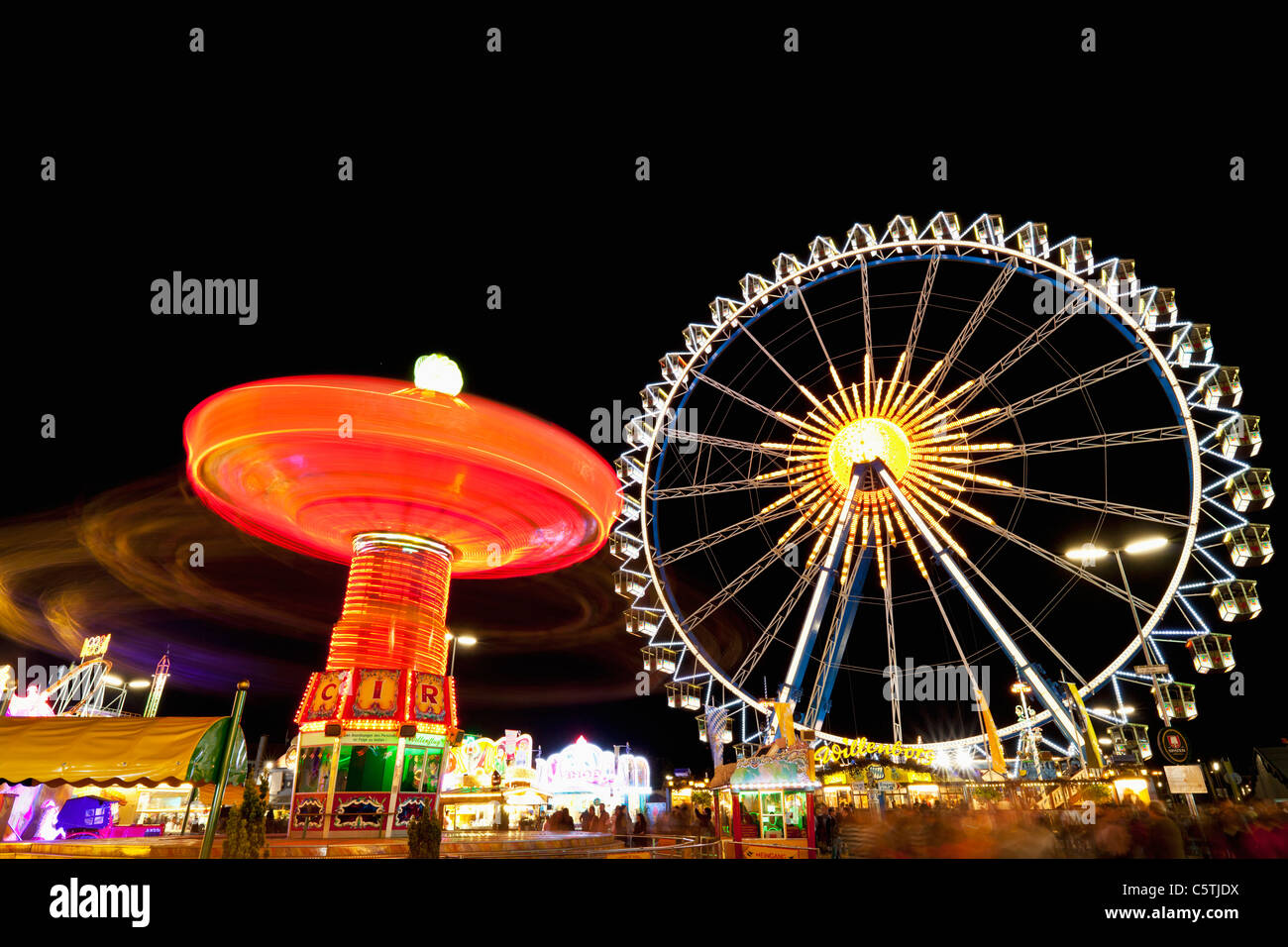 Deutschland, Bayern, München, Blick auf beleuchtete Kettenkarussell und Ferris Wheel in der Nacht Stockfoto