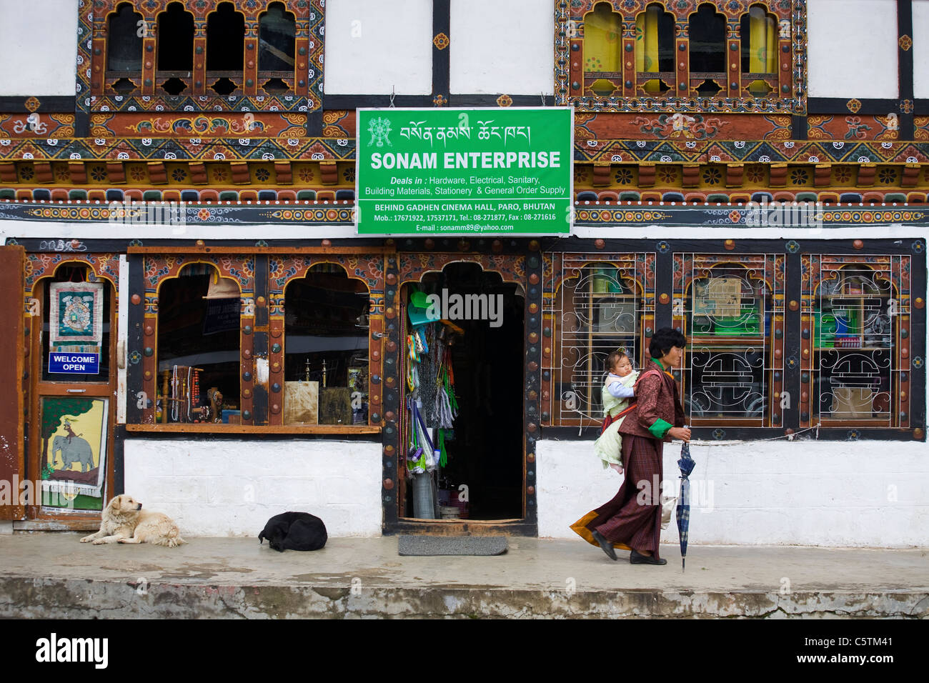 Frau mit ihrem Kind zu Fuß passieren den Shop an Paro-Markt. Bhutan Stockfoto