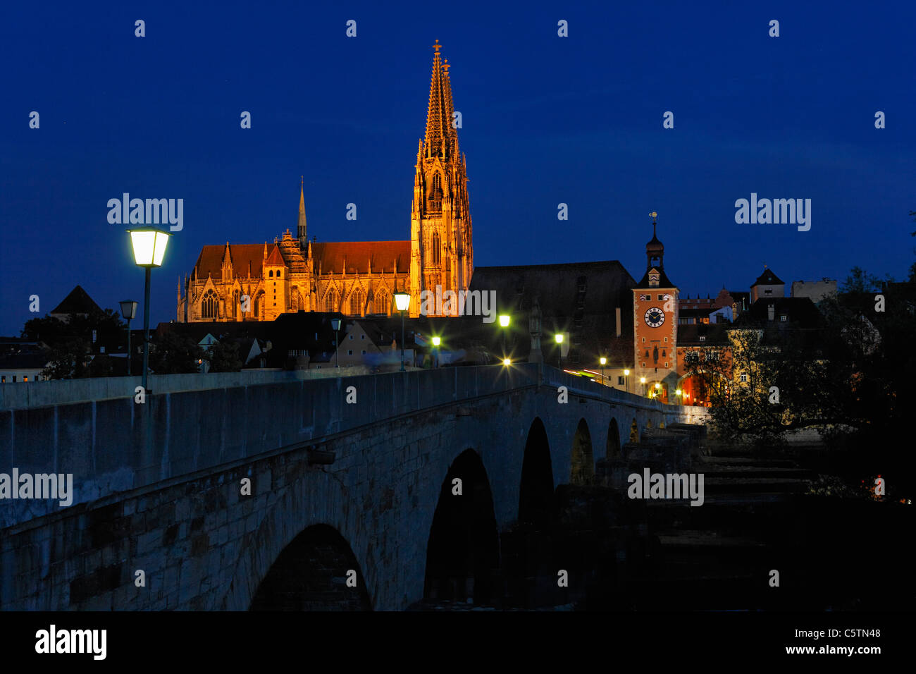 Deutschland, Bayern, Oberpfalz, Regensburg, Ansicht von Bruecktor Tor und Kathedrale mit Steinbrücke auf Donau bei Nacht Stockfoto