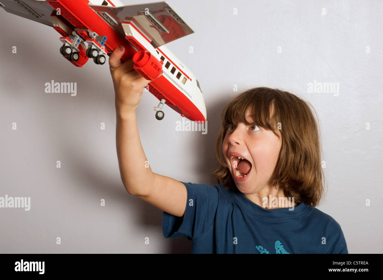Junges Mädchen (Wildfang) spielen mit ein Lego Modell Jet airliner Stockfoto