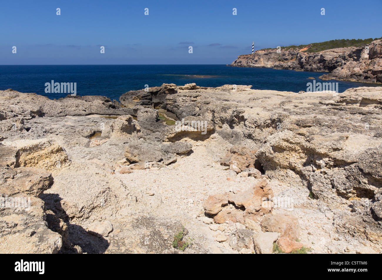 Ibiza, Balearen, Spanien - Portinatx, Nordküste der Insel. Klippe geht auf schroffen Felsen über dem Meer. Stockfoto