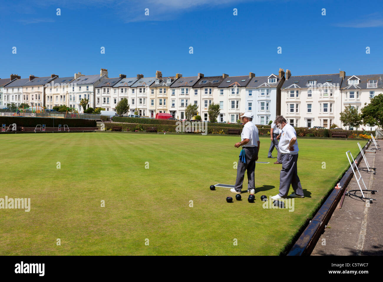 Bowling-Green im Freien mit drei Männern, die Bowlen spielen Seaton Devon England GB Europa Stockfoto