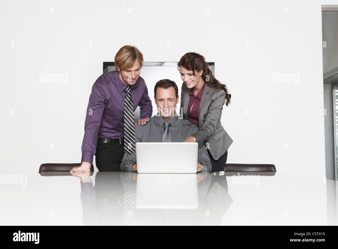 Deutschland, Köln, drei Geschäftsleute im Büro mit laptop Stockfoto