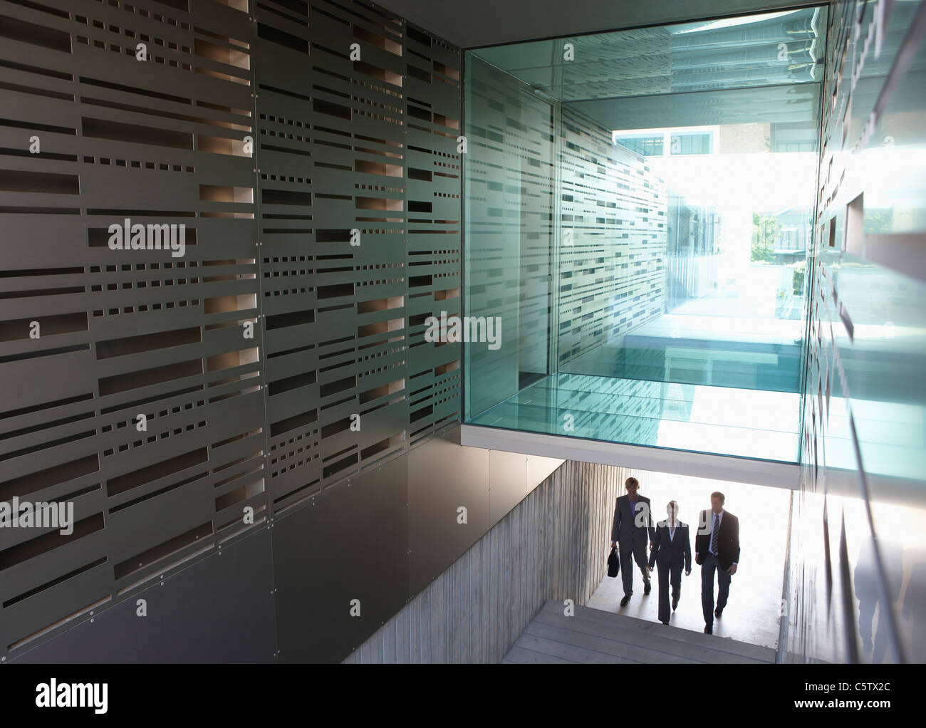 Deutschland, Köln, drei Geschäftsleute im Treppenhaus, erhöht, Ansicht Stockfoto