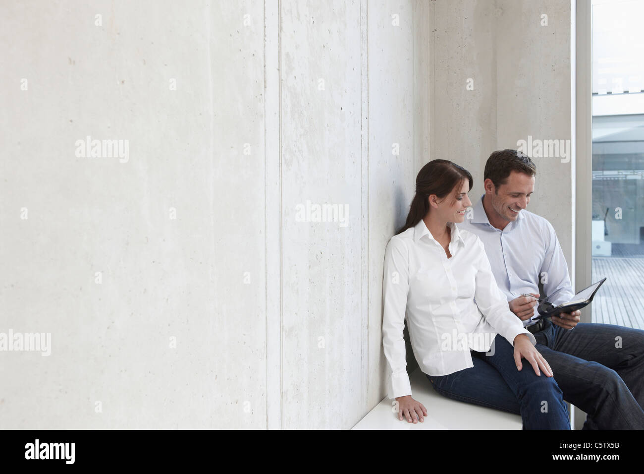 Deutschland, Köln, zwei Geschäftsleute sitzen auf Bank, Geschäftsmann, Besitz persönlichen organizer Stockfoto