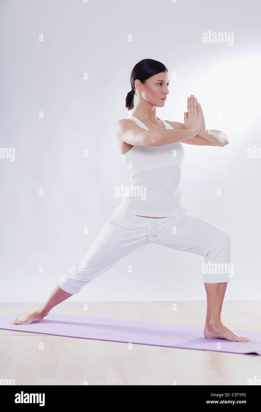 Mitte Erwachsene Frau beim Yoga vor weißem Hintergrund Stockfoto