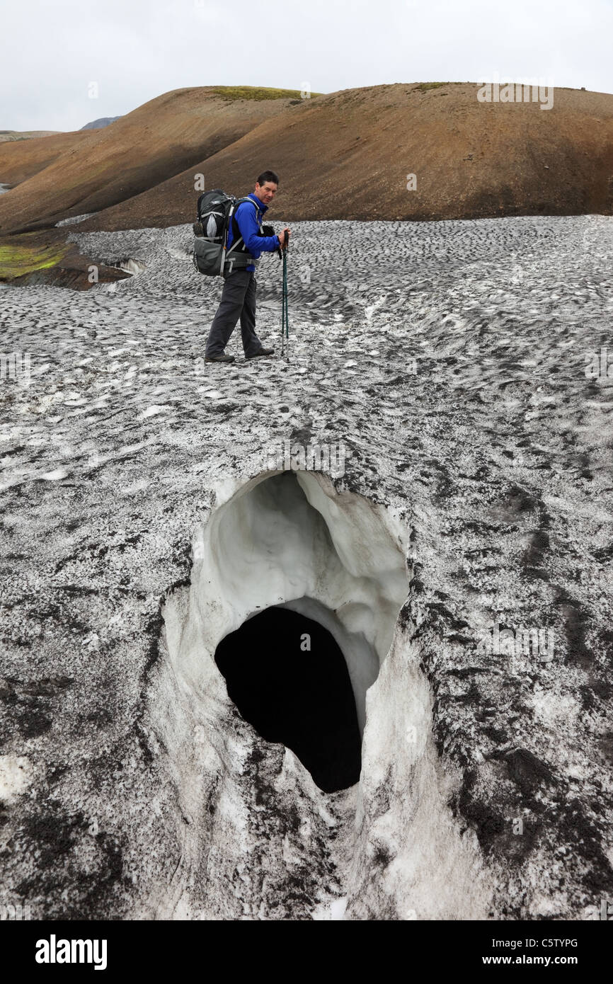 Walker, überqueren eine Gletscherspalte in ein Schneefeld auf der Laugavegur (Laugavegurinn) Wanderweg Island Stockfoto