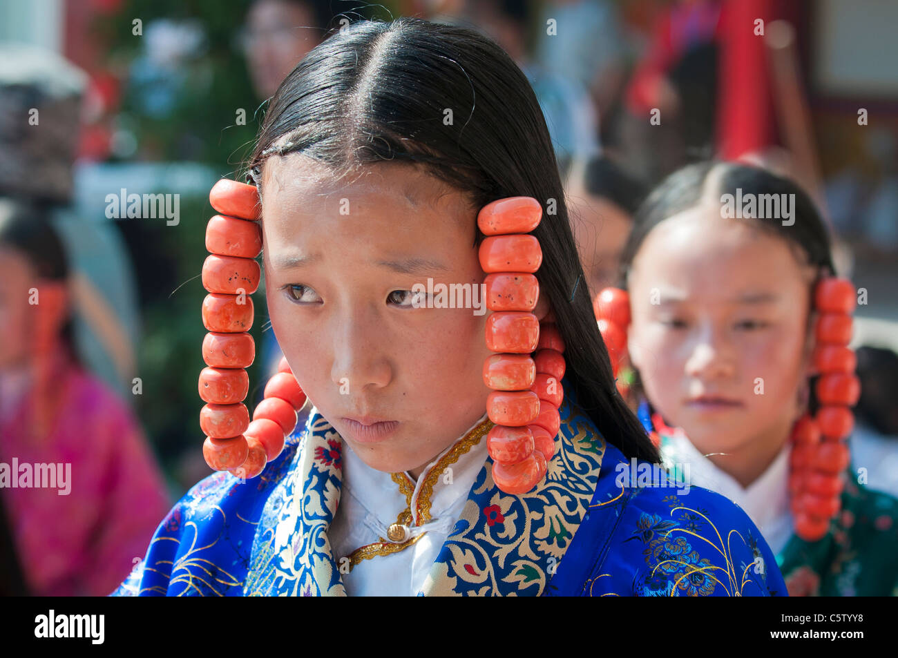 Junge Mädchen tragen von schweren Korallen Schmuck Höchstleistungen Schamane Erntefest, Tongren, Qinghai Provinz, China Stockfoto