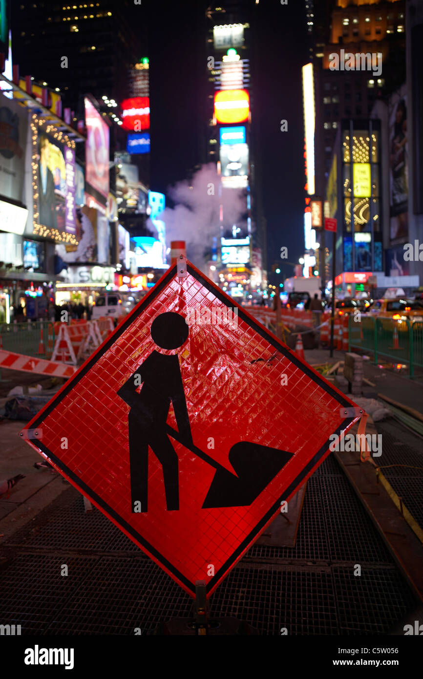 USA, New York City, Manhattan, Work In Progress-Zeichen im Vordergrund, Times Square bei Nacht Stockfoto