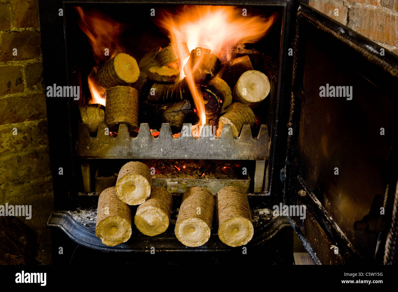 Komprimierte Hackschnitzel- und Sägespäne Pellets in einem Log-Korb bereit sind, einen Haushalt Holzofen macht Stockfoto