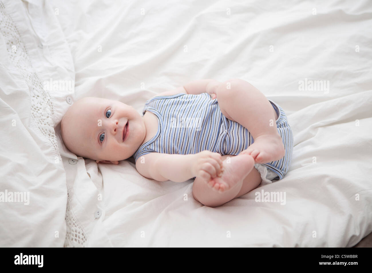 Deutschland, München, (2-5 Monate) Baby Boy auf Bett, Porträt Stockfoto