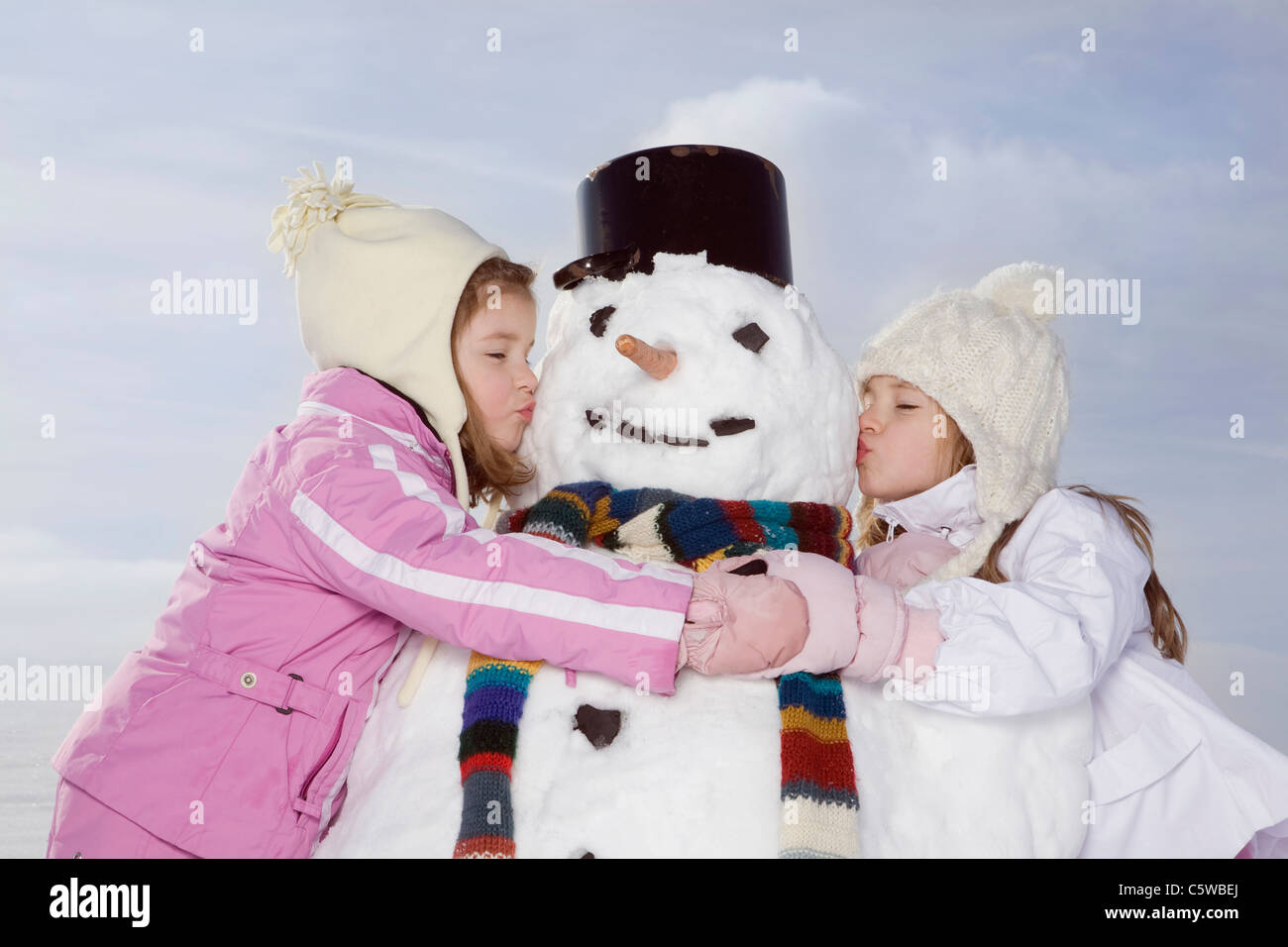 Deutschland, Bayern, München, zwei Mädchen (4-5) (8-9) küssen Schneemann, Augen geschlossen, Porträt Stockfoto