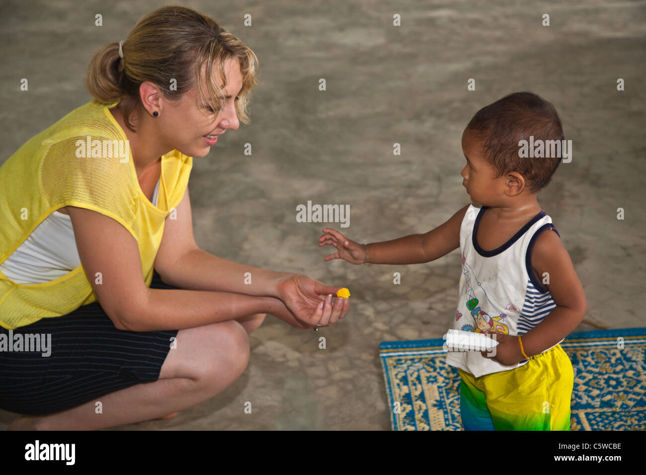 Ein freiwilliger spielt mit einem thailändischen jungen in Ben du Lion auf KOH PHRA THONG ISLAND - THAILAND Stockfoto