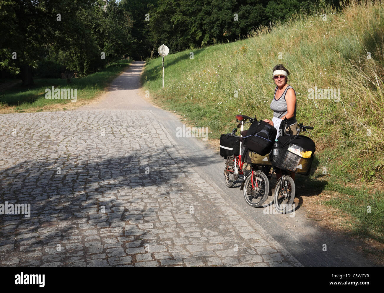 Ein Reifen weiblichen Radfahrer steht mit Brompton Falträder zwischen Vockerode und Pretzch auf dem Elbe-Radweg Deutschland. Stockfoto
