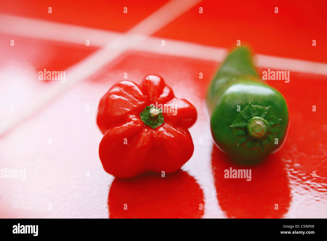 Paprika und Chili Pod auf rote Fliesen Stockfoto