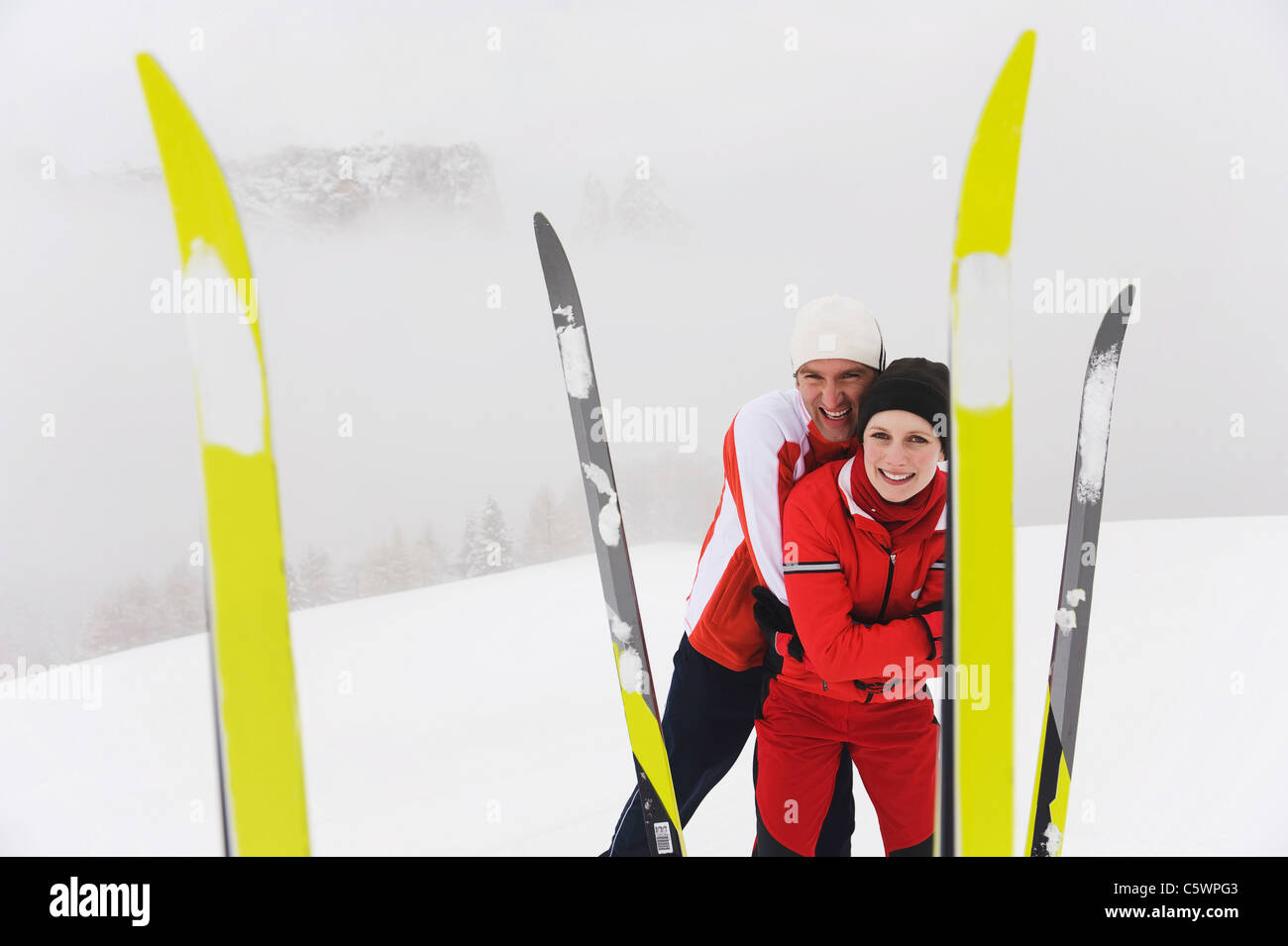 Italien, Südtirol, paar in alle R Kleidung, Lächeln, Ski im Vordergrund Stockfoto
