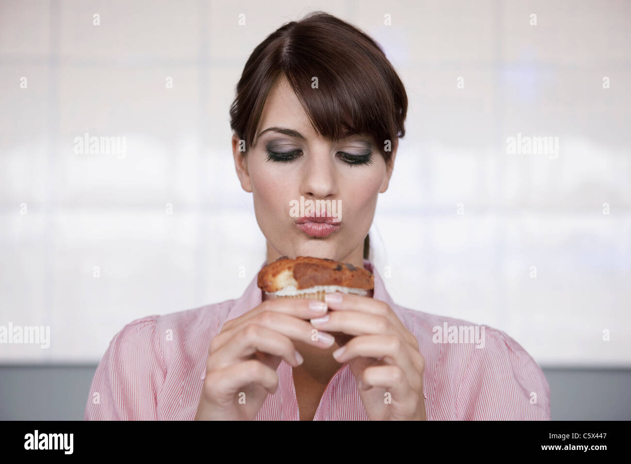 Deutschland, Köln, junge Frau mit einem muffin Stockfoto