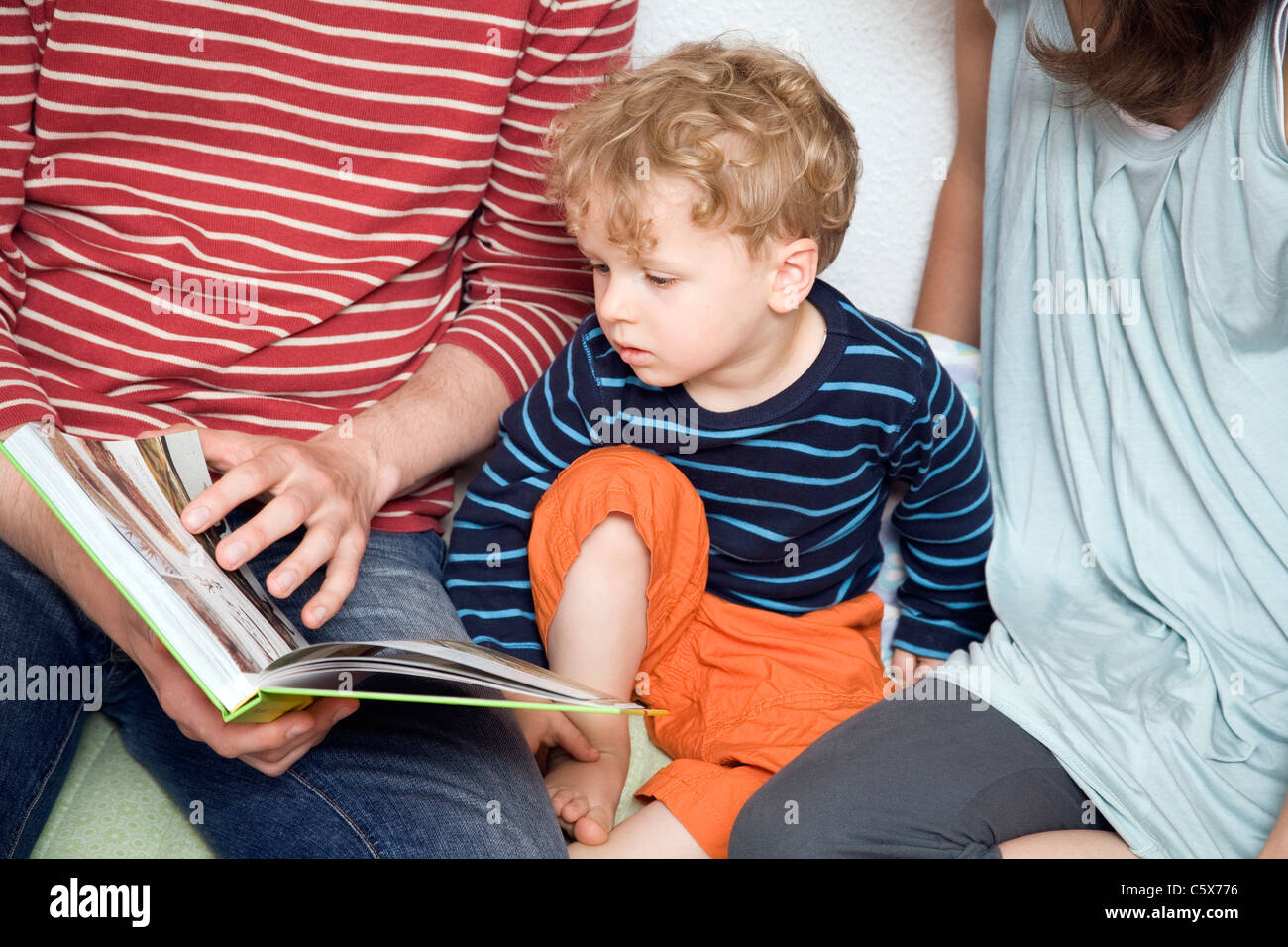 Deutschland, Berlin, Eltern und Sohn (3-4) ein Buch lesen, close-up Stockfoto