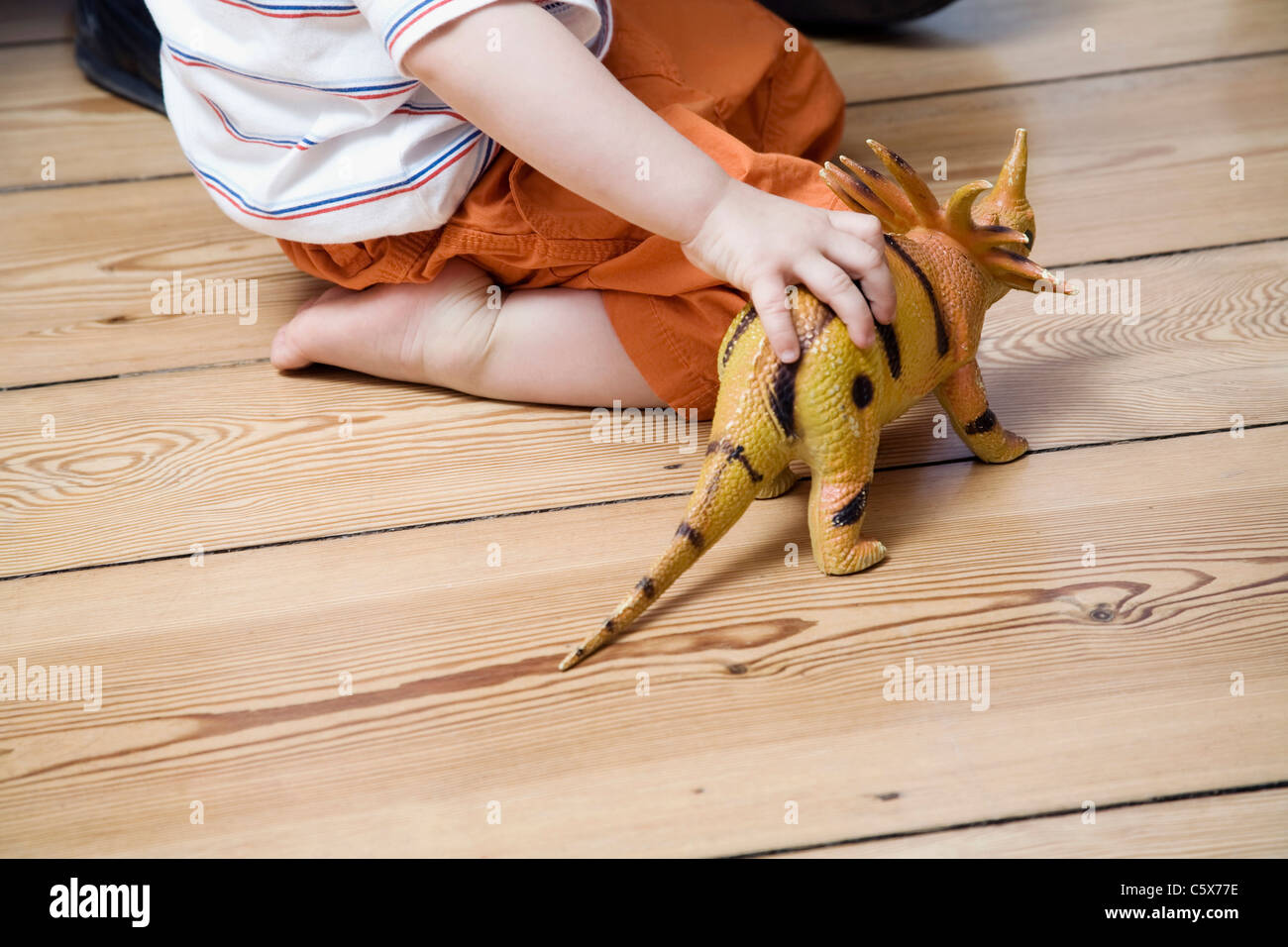 Deutschland, Berlin, Kind spielt mit Spielzeug Dinosaurier Stockfoto